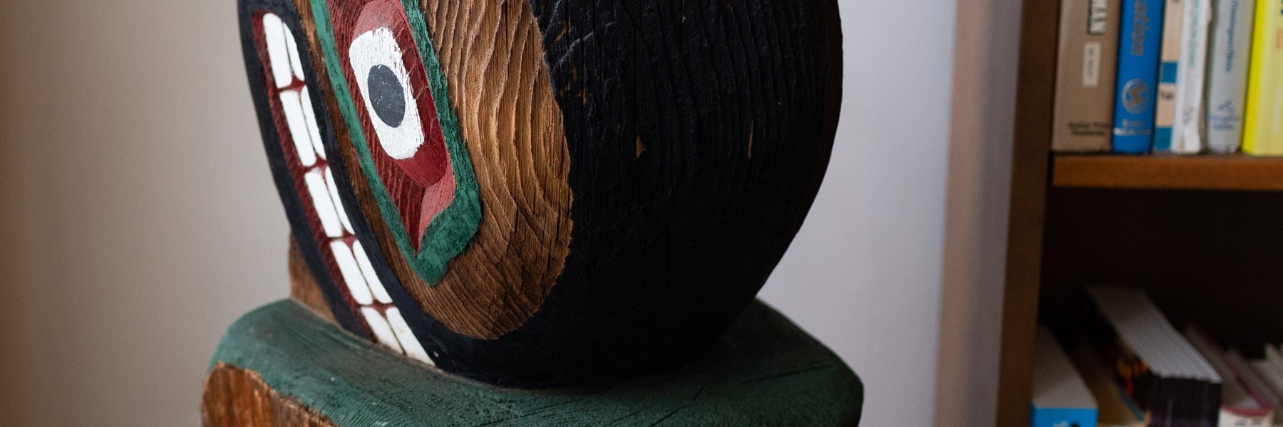 A  brightly painted section of a Native American totem pole at the Ostrom Workshop. 